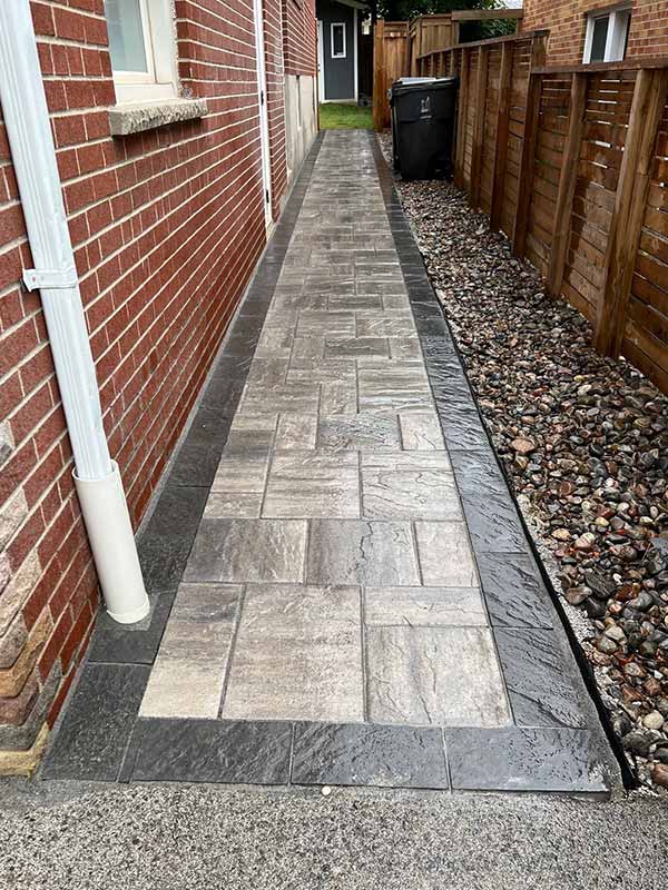 Interlocking Stone Pathway between house and wooden fence